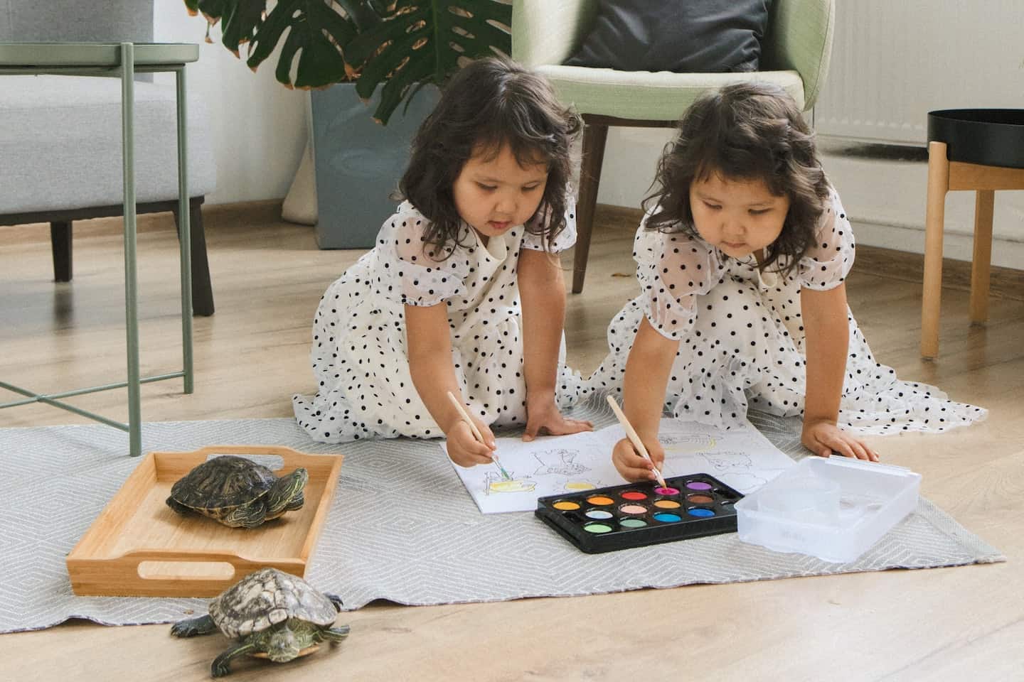 twin girls coloring on the floor