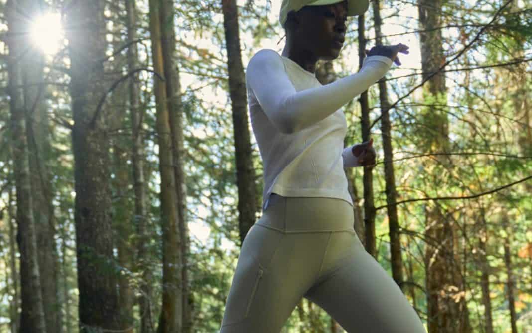woman wearing athleta leggings running in the woods