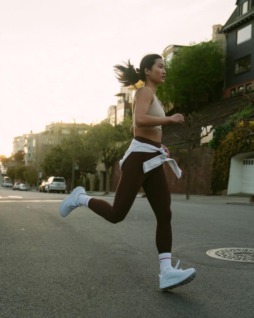 woman running the streets wearing the energy bra and Swift Speed Tight by lululemon